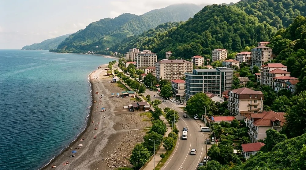 Spiaggia di ciottoli, edifici e colline lungo la costa di Gonio e Kvariati